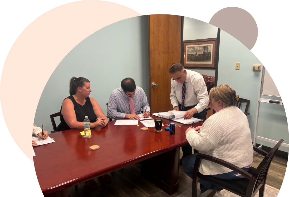 Paul Ferraresi is working with his team at a conference table.